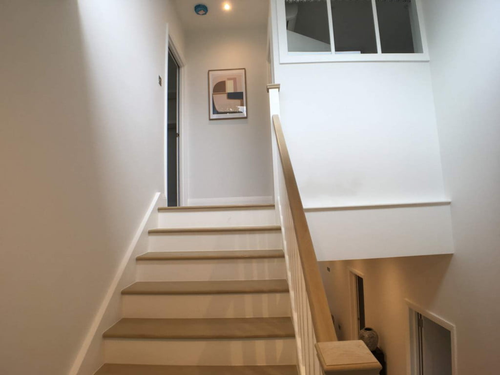 light solid brown wooden residential stairs leading to a loft room